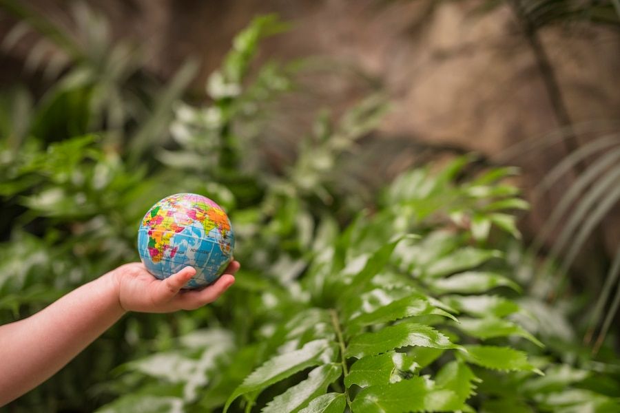 Mano de un niño sosteniendo un globo terráqueo hinchable