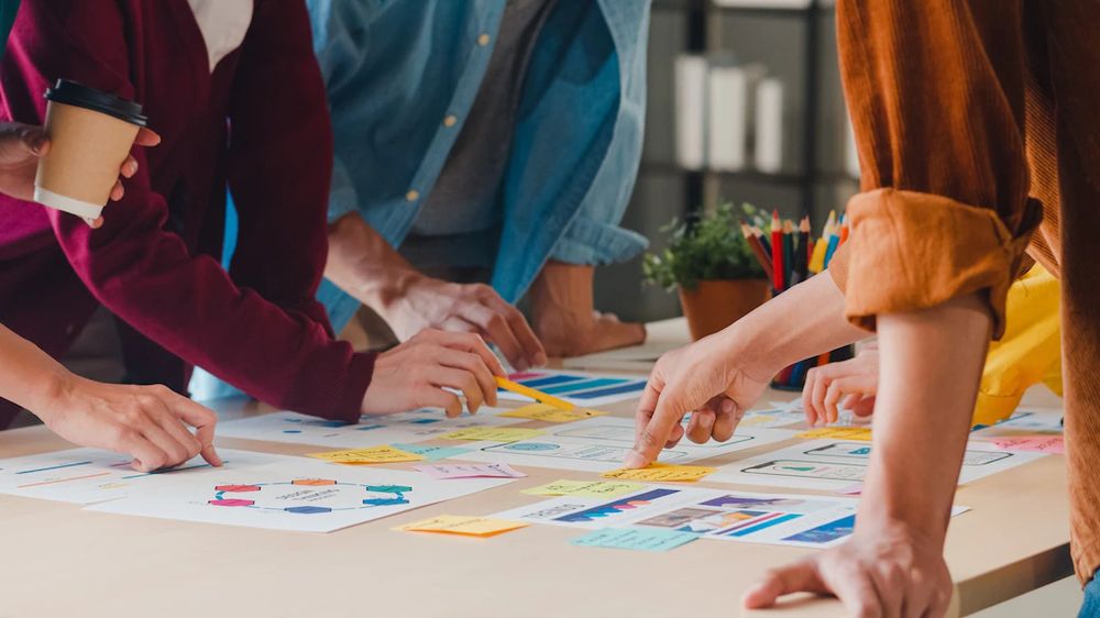 Equipo de trabajo planificando sobre una mesa con documentos