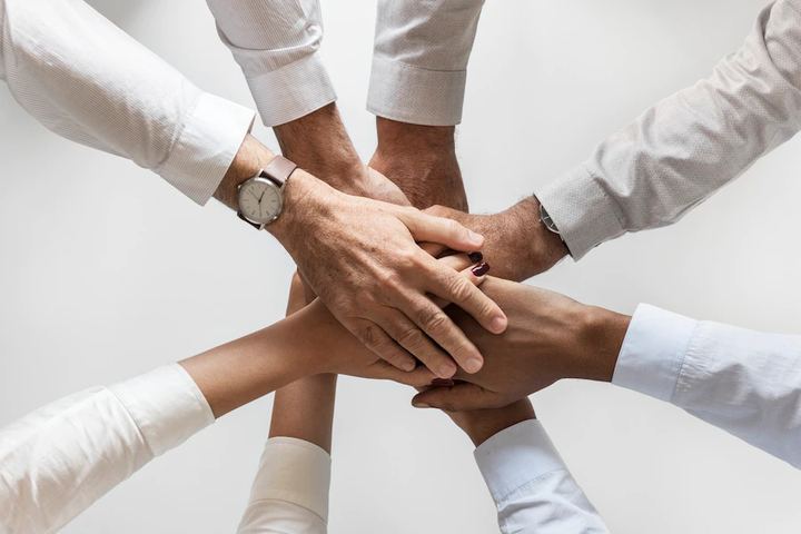 Manos de un equipo unidas en el centro